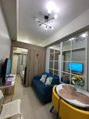 a living room with a blue couch and a table at Key and Stay in Manila
