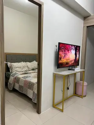 a bedroom with a bed and a television on a table at Key and Stay in Manila
