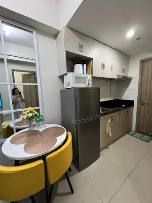 a kitchen with a table and yellow chairs in a room at Key and Stay in Manila
