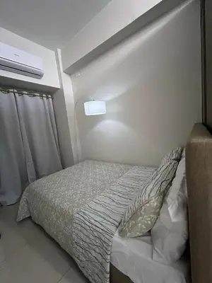 a bedroom with a bed and a light on the wall at Key and Stay in Manila