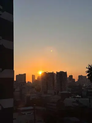 a city skyline with the sun setting in the horizon at Affordable Staycation Home in Makati in Manila