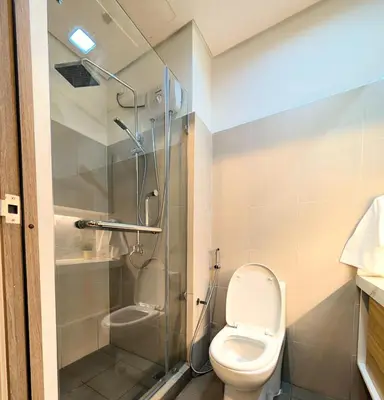 a bathroom with a toilet and a glass shower at Cozy Modern Sunset View in Manila
