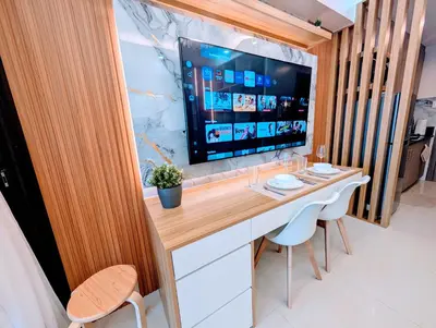 a room with a desk with a television and chairs at Cozy Modern Sunset View in Manila