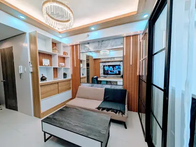 a small living room with a couch and a tv at Cozy Modern Sunset View in Manila