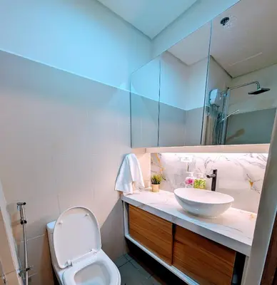 a bathroom with a sink and a toilet and a mirror at Cozy Modern Sunset View in Manila