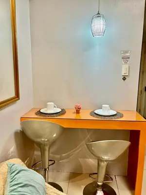 a table with two plates and two cups on it at Sarah's Staycation at Sea Residences Near Moa in Manila
