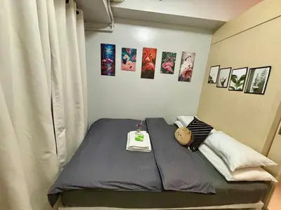 a room with a bed with pictures on the wall at Sarah's Staycation at Sea Residences Near Moa in Manila
