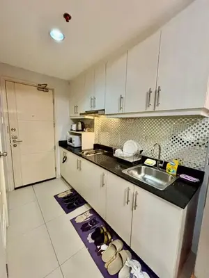 a kitchen with a sink and a counter top at Sarah's Staycation at Sea Residences Near Moa in Manila