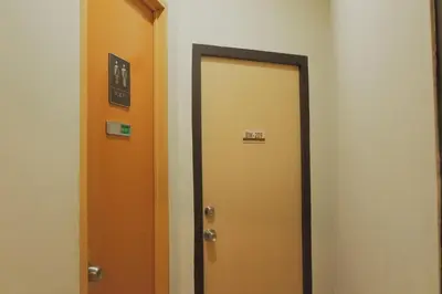 a hallway with two elevators and a yellow door at Brightwood Hotel & Residences in Manila