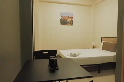 a small hotel room with a bed and a table at Brightwood Hotel & Residences in Manila