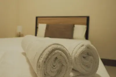 a pile of towels sitting on top of a bed at Brightwood Hotel & Residences in Manila