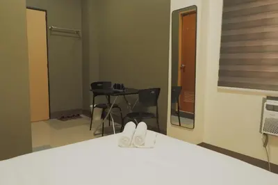 a room with a mirror and a table with chairs at Brightwood Hotel & Residences in Manila