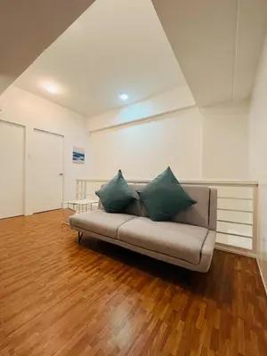 a couch with two green pillows in a room at Cedrosa Lofts GA Tower in Manila