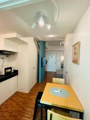 a dining room and kitchen with a table and chairs at Cedrosa Lofts GA Tower in Manila
