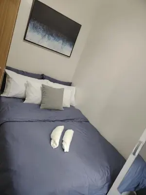 a bedroom with a blue bed with two white pillows at Shore 3 Tower 30372 in Manila