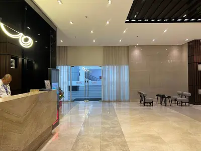 a lobby with a counter and chairs in a building at Cozy Condo Apartment in Red Residences Makati near malls and airport in Manila