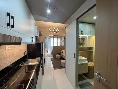 a kitchen with a sink and a living room at Cozy Condo Apartment in Red Residences Makati near malls and airport in Manila