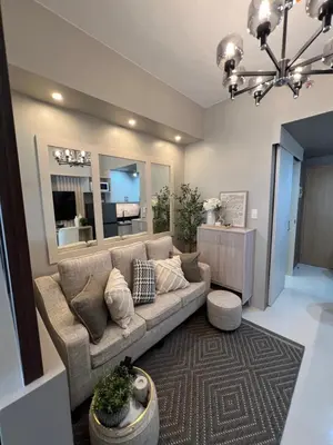 a living room with a couch and a large mirror at Cozy Condo Apartment in Red Residences Makati near malls and airport in Manila
