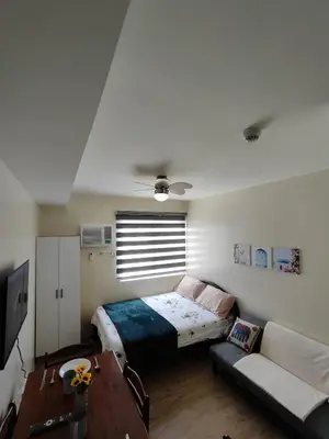 a bedroom with a bed and a couch at Sweet, Simple and Stylish Studio in Silang