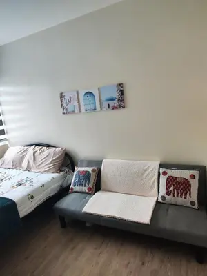 a living room with a couch and a bed at Sweet, Simple and Stylish Studio in Silang