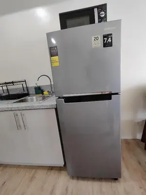 a stainless steel refrigerator in a kitchen with a sink at Sweet, Simple and Stylish Studio in Silang
