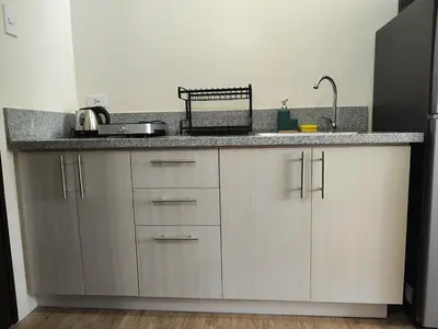 a kitchen with a sink and a counter top at Sweet, Simple and Stylish Studio in Silang