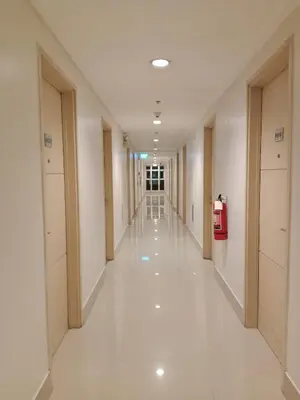 an empty hallway in a building with white floors at Sea Residence Tower EF Lets in Manila