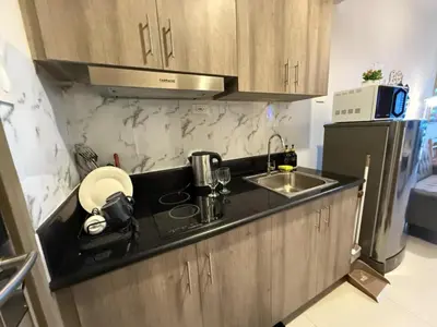 a small kitchen with a sink and a refrigerator at Coastresidences by Rinseiki in Manila