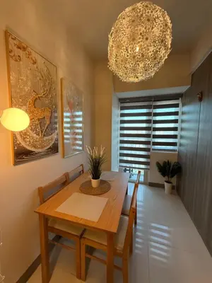 a dining room with a table and chairs and a chandelier at Coastresidences by Rinseiki in Manila
