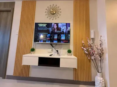 a living room with a tv on a wall at Coastresidences by Rinseiki in Manila