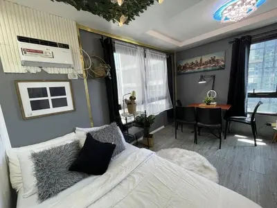 a bedroom with a bed and a desk in a room at Stylish unit in Ortigas near podium & holiday inn in Manila