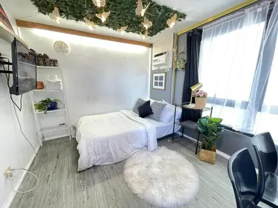 a bedroom with a white bed and a white rug at Stylish unit in Ortigas near podium & holiday inn in Manila