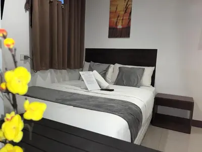 a bedroom with a large bed with yellow flowers at Harrison Suites in Manila