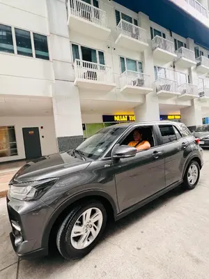 a man sitting in a car parked in front of a building at Sea Residence MOA Prime by Paul in Manila