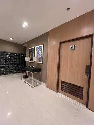 a lobby with a door and a desk next to it at Sea Residence MOA Prime by Paul in Manila