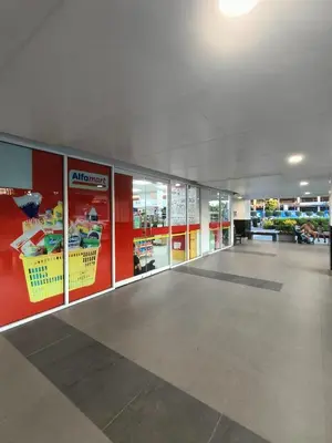 an empty aisle of a grocery store with glass doors at Shell Residences By Jhem Place in Manila