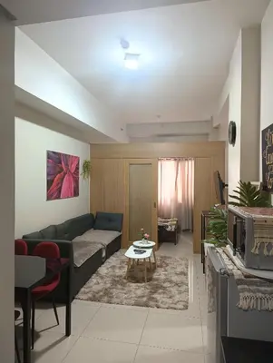 a living room with a couch and a table at Shell Residences By Jhem Place in Manila