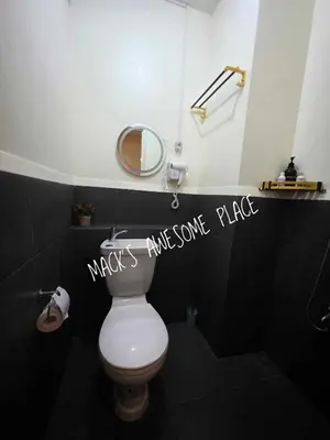 a bathroom with a white toilet and a mirror at CUBAO Macks Awesome Place NETFLIX UNLIFAST WIFI in Manila