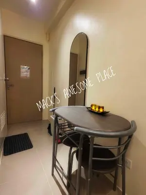 a dining room table with a mirror and a table with chairs at CUBAO Macks Awesome Place NETFLIX UNLIFAST WIFI in Manila