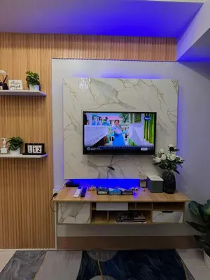 a living room with a television on a wall at Shore3 Residences Tower2 Staycation in Manila