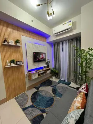 a living room with a tv and a large rug at Shore3 Residences Tower2 Staycation in Manila