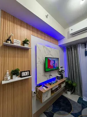 a room with a television on a wall with purple lights at Shore3 Residences Tower2 Staycation in Manila