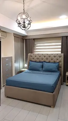 a bedroom with a blue bed and a chandelier at 2 BR, 2 Full Bathrooms, with hotel feels and a jet tub in Manila