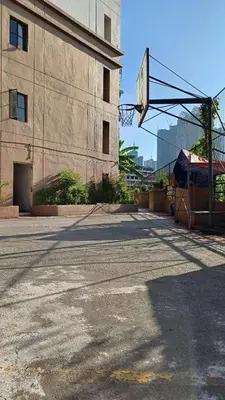 an empty parking lot next to a building with a basketball hoop at 2 BR, 2 Full Bathrooms, with hotel feels and a jet tub in Manila