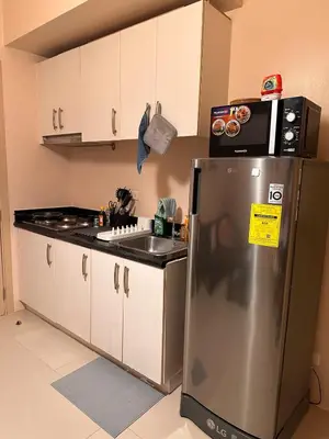 a kitchen with a stainless steel refrigerator and a sink at The Essential 2 BR at Sm Jazz makati 100 mbps in Manila