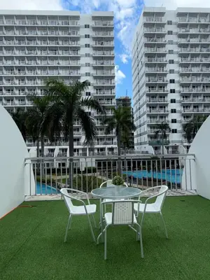 a patio with a table and chairs and buildings at Spacious pool view at Mall of Asia 100mb Netflix in Manila