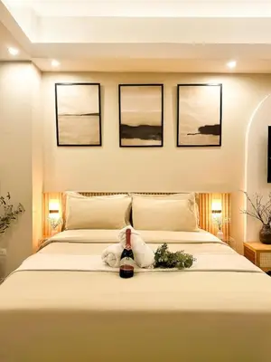 a bedroom with a bed with a bottle of wine on it at Exquisite Japandi 2 & Mediterranean Breeze at Venice w Grand Canal View! in Manila