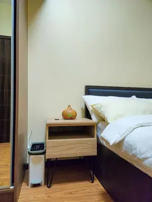 a bed with a wooden nightstand next to a bed sidx sidx sidx at Galini Suites in Manila