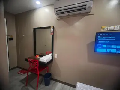 a room with a red chair and a tv on the wall at Hotel Sogo EDSA Shaw Blvd in Manila