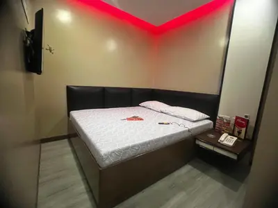 a small room with a bed with a red light at Hotel Sogo EDSA Shaw Blvd in Manila